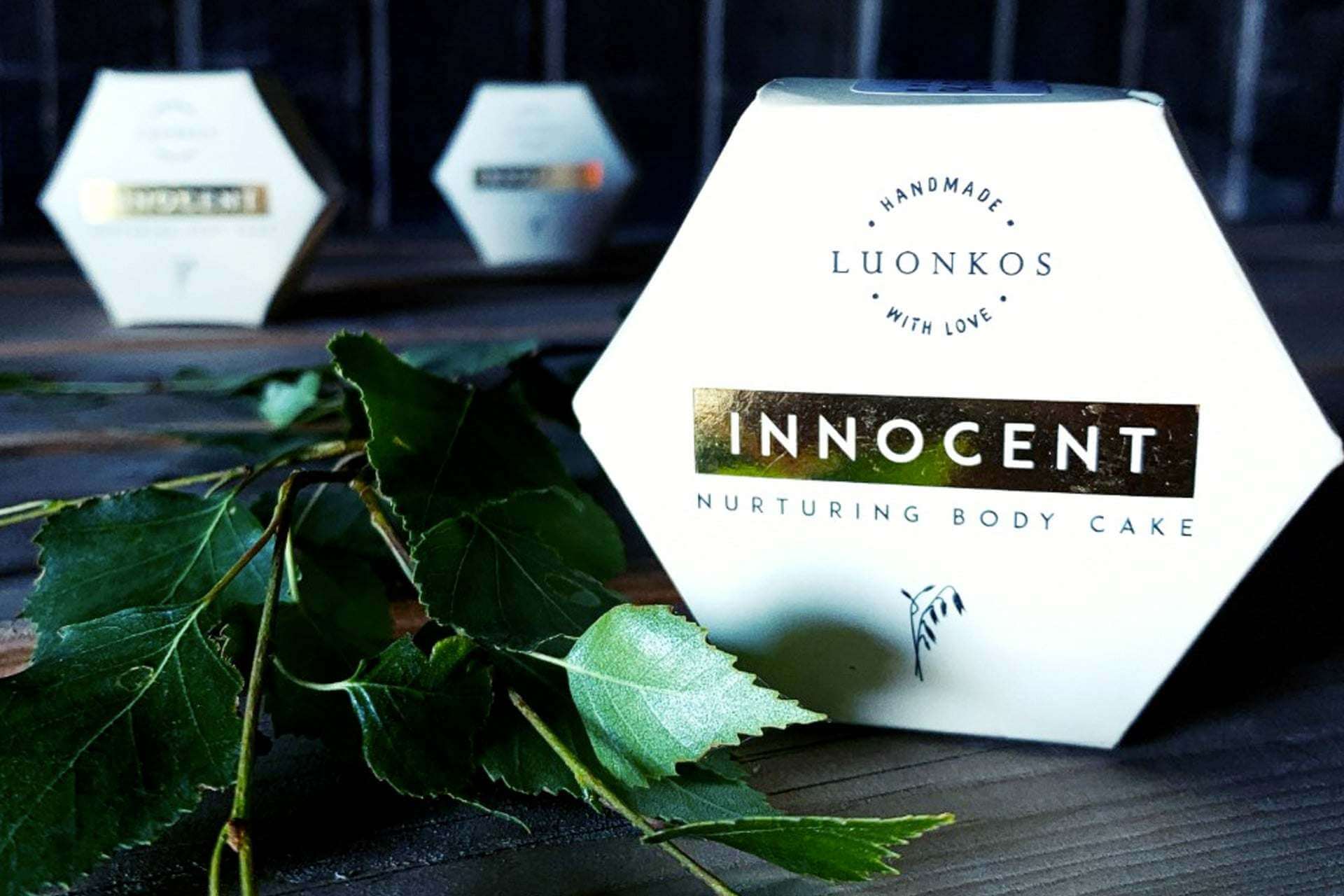 Luonkosin Innocent nurturing body cake hexagonal packaging with green leaves on wooden surface for dry and sensitive skin care