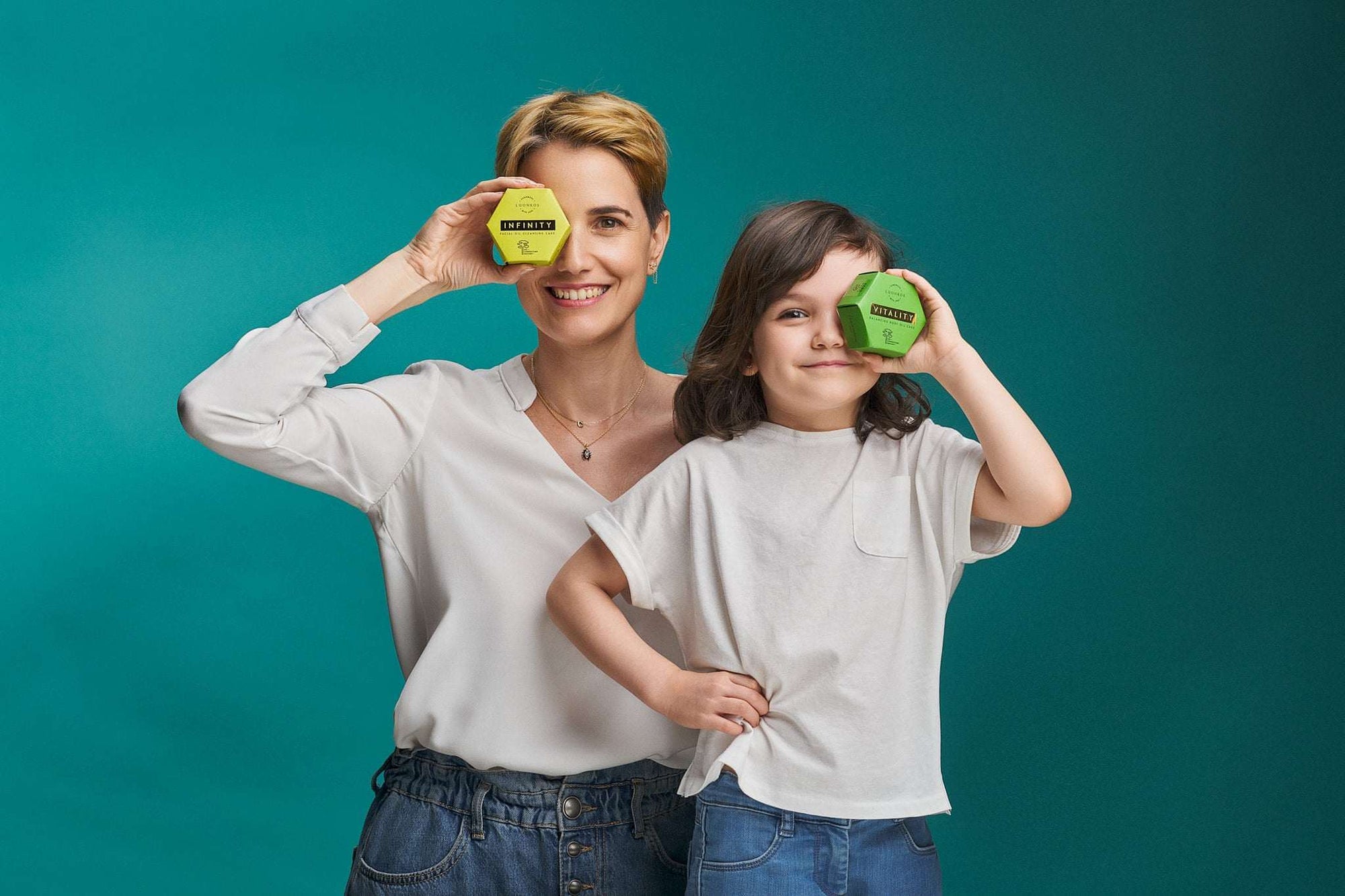 Mother and child holding Luonkos skincare products for atopic skin against teal background