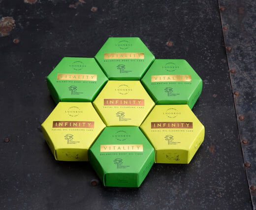 Voima-tuotesarja hexagonal green and yellow skincare oil cleansing bars arranged on dark surface