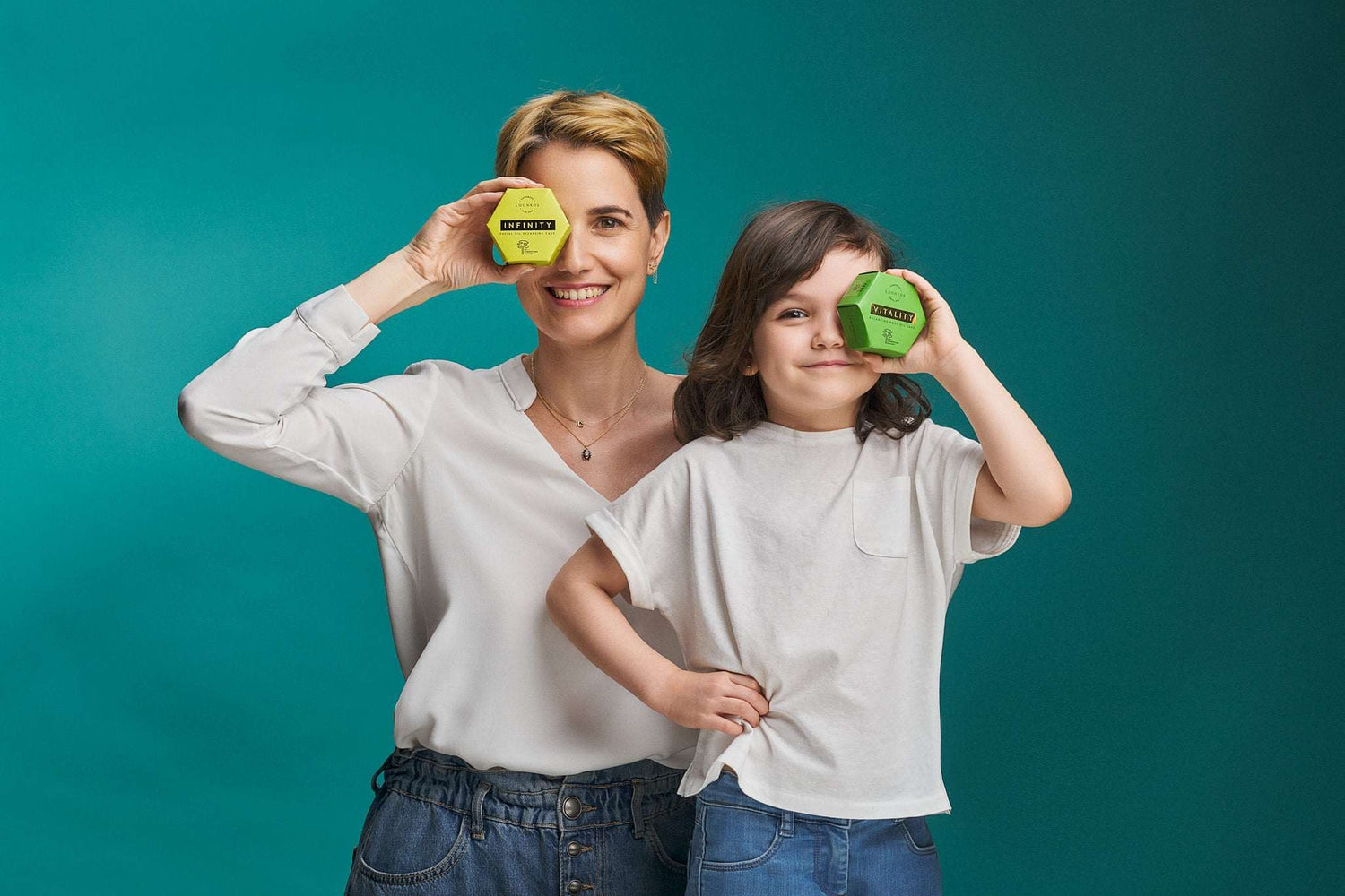 Mother and child holding Luonkos skincare products for atopic skin against teal background