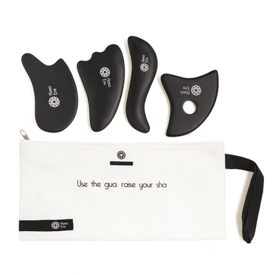 Neliosainen musta Gua Sha hierontakivisetti Bian-kivestä kasvoille ja vartalolle, mukana valkoinen säilytyspussi.