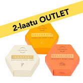 Set of three Luonkos 2nd quality vartaloöljykakku body oil cakes in orange, white, and coral hexagonal packaging with outlet discount banner