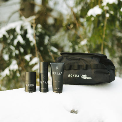 Rokua Skincare miesten tuotteet ja Jack Wolfskin -laukku lumisessa metsässä
